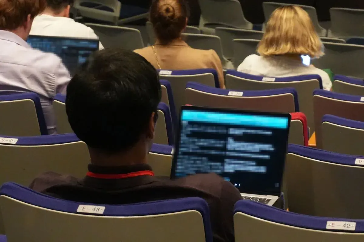 客席でノートPCに日英の翻訳テキストを表示して聴講する参加者