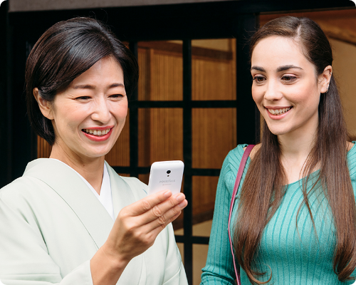 日本に来た旅行者の方とポケトークを利用して会話している写真